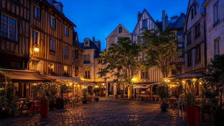 Ambiance romantique inspirée du Vieux Tours avec maisons à pans de bois, place animée et lumière bleue