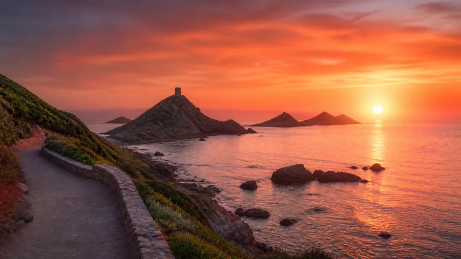 Ambiance romantique inspirée d'Ajaccio et des Îles Sanguinaires avec sentier côtier et coucher de soleil rouge